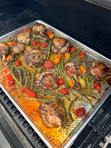 a sheet tray covered with cooked chicken, green beans, and cherry tomatos