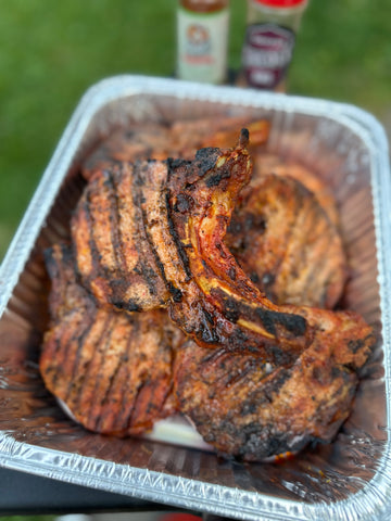 an aluminum pan full of grilled pork chops