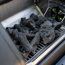 A pile of unlit Char-Griller Lump Charcoal sits ready for use on the adjustable height charcoal grate in a FlexFuel grill